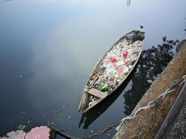 small boats transporting garbage in the river. located in the city of Daan Mogot, Jakarta, August 13, 2022. photo