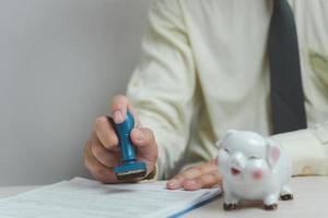 Man stamping approval of work finance banking or investment marketing documents on desk. photo