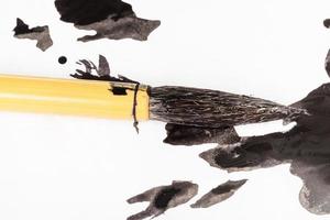 black painted tip of paintbrush over ink blots photo