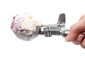 side view of ball of ice cream in disher scoop photo