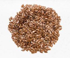 pile of brown flax seeds close up on gray photo