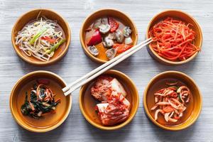 chopsticks on bowls with various side dishes photo