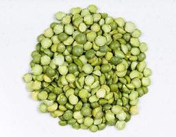 pile of dried green split peas close up on gray photo