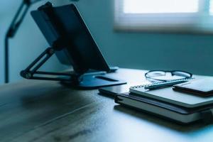 Stylish workplace with telephone and tablet PC on table in home office, beautiful blue fillter photo