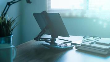 Stylish workplace with telephone and tablet PC on table in home office, beautiful blue fillter photo