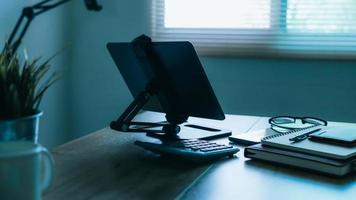 Stylish workplace with telephone and tablet PC on table in home office, beautiful blue fillter photo