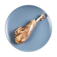 top view of single boiled turkey leg on blue plate photo