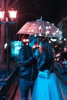 Guy and girl kissing under an umbrella photo