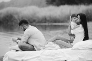 Happy young family relaxing together on the lake photo