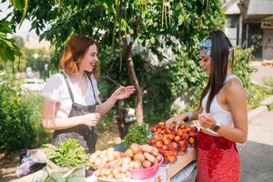 mujer vendedora ofrece verduras frescas y orgánicas en el mercado de agricultores. foto