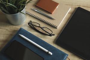 Workplace Desktop home office. Top view of table, laptop, glass, documents, tablet, business card, purse, calculator, pen, books,coffee. Business background, organization. photo