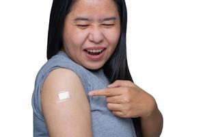 mujer asiática de mediana edad que siente dolor y dolor muscular en el brazo, tiene algunos efectos secundarios después de recibir inmunidad vacunada con un vendaje en la parte superior del brazo. concepto médico y saludable foto