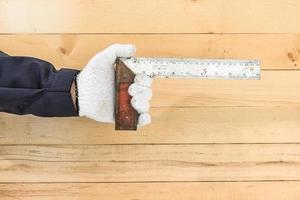 Hand in glove holding iron ruler photo