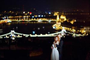 encantadora novia y novio en un fondo de budapest foto