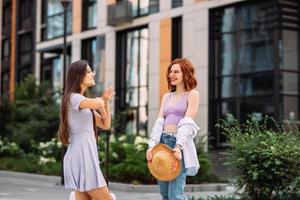 dos hermosas mujeres hablando y de pie al aire libre foto