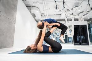 joven madre adulta haciendo ejercicio con su pequeña hija foto