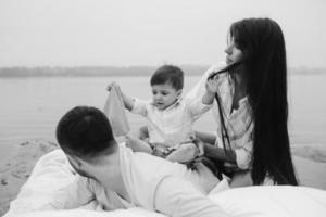 Happy young family relaxing together on the lake photo