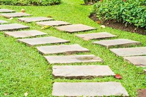 Stone path in park on green grass photo