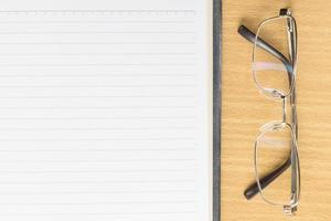Notebook open blank page and eyeglasses photo
