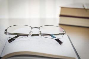 Eyeglasses put on notebook on wood table photo