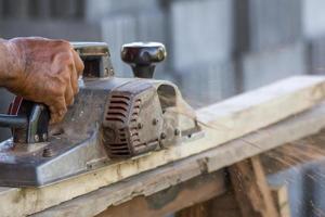 Carpenter working with electric planer photo