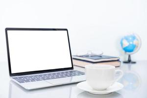 Laptop mockup and coffee cup on table photo