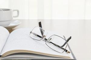 Eyeglasses put on a book with on the desk photo