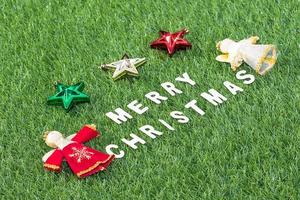 Top view Christmas alphabet and decoration on green grass photo