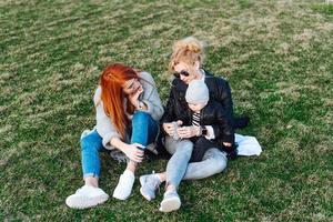 Mom and aunt play with a boy in the Park photo