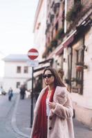 young beautiful stylish woman walking in pink coat photo