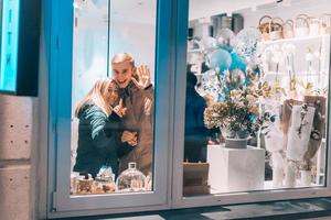 Photo through window. Young couple in cafe with stylish interior