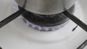 cacerola en primer plano de fuego. cocinar en una olla en una estufa de gas. quemador de gas en la cocina para cocinar. cocina a gas con estufa a gas propano a fuego. concepto de gas natural. video