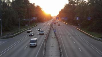 in beweging auto's Aan de snelweg gedurende zonsondergang. bezig verkeer Aan een snelweg of snelweg, top visie van de weg. de gouden stralen van de avond zon verlichten de vervoer. Oekraïne, kyiv - oktober 3, 2021. video