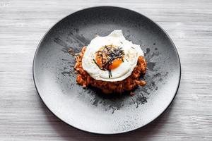 Kimchi bokkeum bap on black plate on wooden board photo