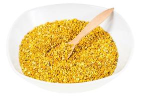 bowl with wooden spoon and bee pollen isolated photo