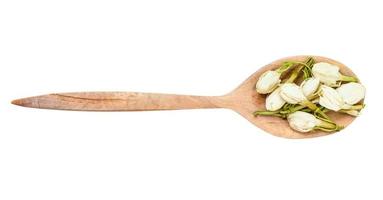 top view of dried jasmine flowers in wood spoon photo