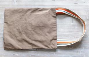 bandolera de doble asa de tela marrón sobre fondo gris foto