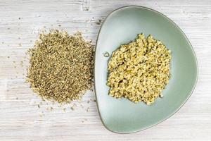 top view of raw freekeh wheat grains and porridge photo