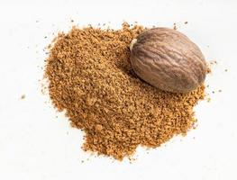 nutmeg seed and powder close up on gray photo