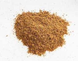 top view of pile of nutmeg powder close up on gray photo