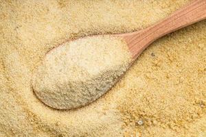 view of wood spoon with granulated coconut sugar photo