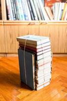 stack of old book tied with twine on wooden floor photo