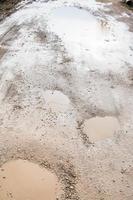 ground road with rainy puddles in spring photo