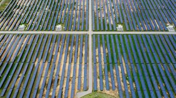 vista aérea da usina de energia solar em campo verde. sistema de painéis solares para geração de energia solar. energia verde para o desenvolvimento sustentável para prevenir as mudanças climáticas e o aquecimento global para proteger a terra.