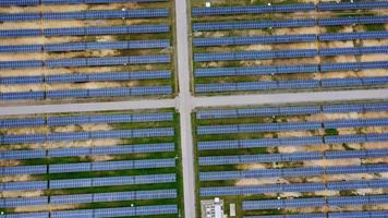 Luftaufnahme des Solarkraftwerks auf der grünen Wiese. Sonnenkollektorsystem zur Erzeugung von Solarstrom. grüne energie für nachhaltige entwicklung zur vorbeugung des klimawandels und der erderwärmung zum schutz der erde. video