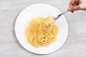 top view fork with spaghetti over white plate photo