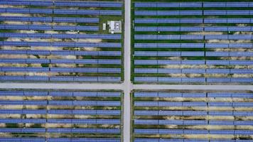 vista aérea de la planta de energía solar en campo verde. sistema de paneles solares para la generación de energía solar. energía verde para el desarrollo sostenible para prevenir el cambio climático y el calentamiento global para proteger la tierra. video