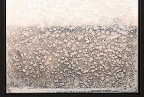 copos de nieve y patrón de escarcha en la ventana de casa congelada foto