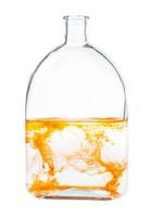 orange watercolour dissolving in water in flask photo