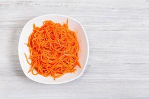 spicy carrots in bowl on gray with copyspace photo